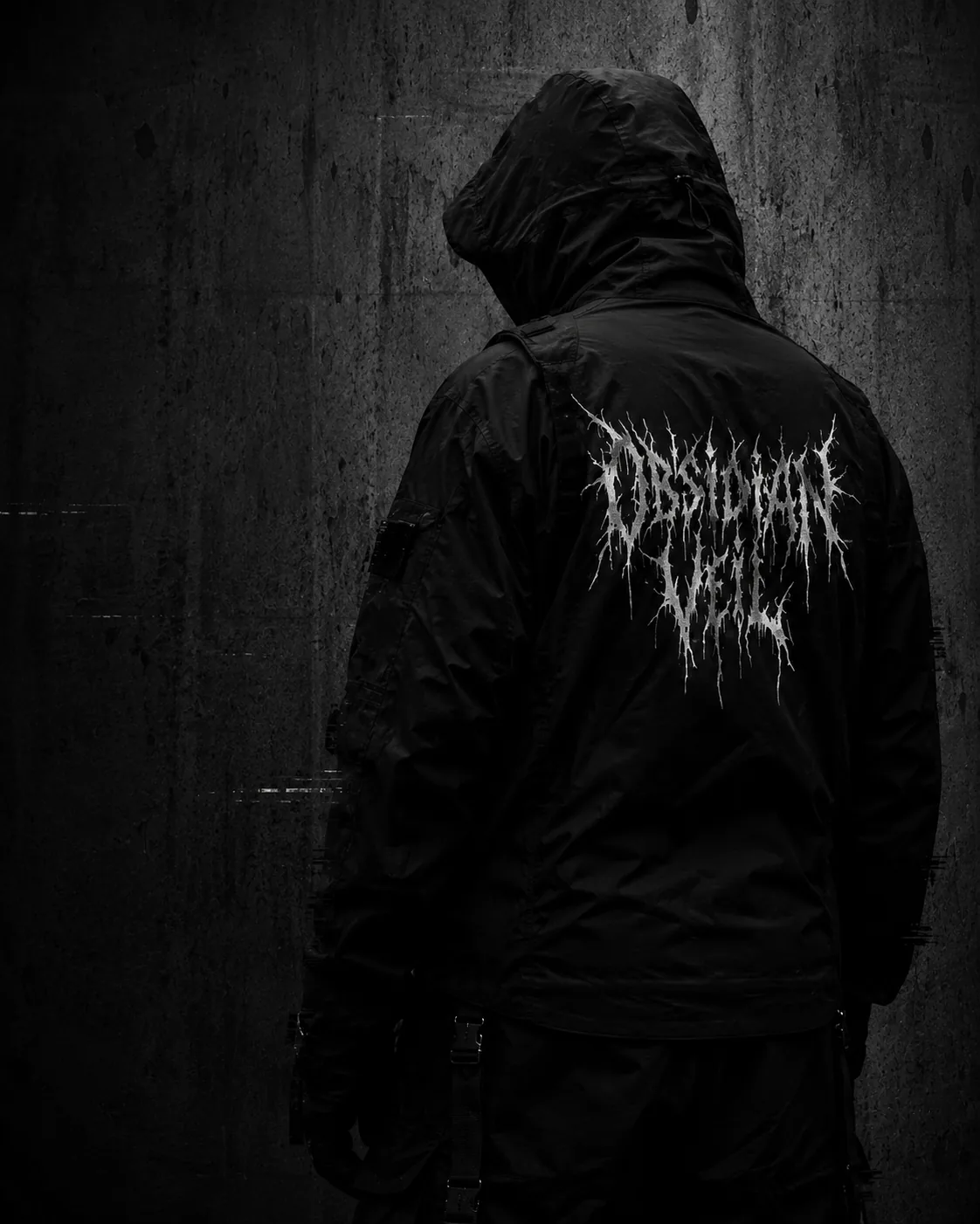 Rear view of a black shell jacket with white black-metal back graphic